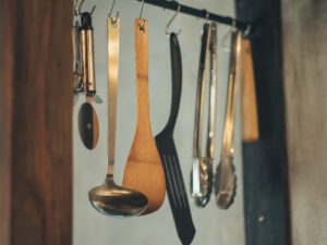 ネドコロノラのキッチンに吊るされた木べら・おたま・フライ返しなどの調理器具